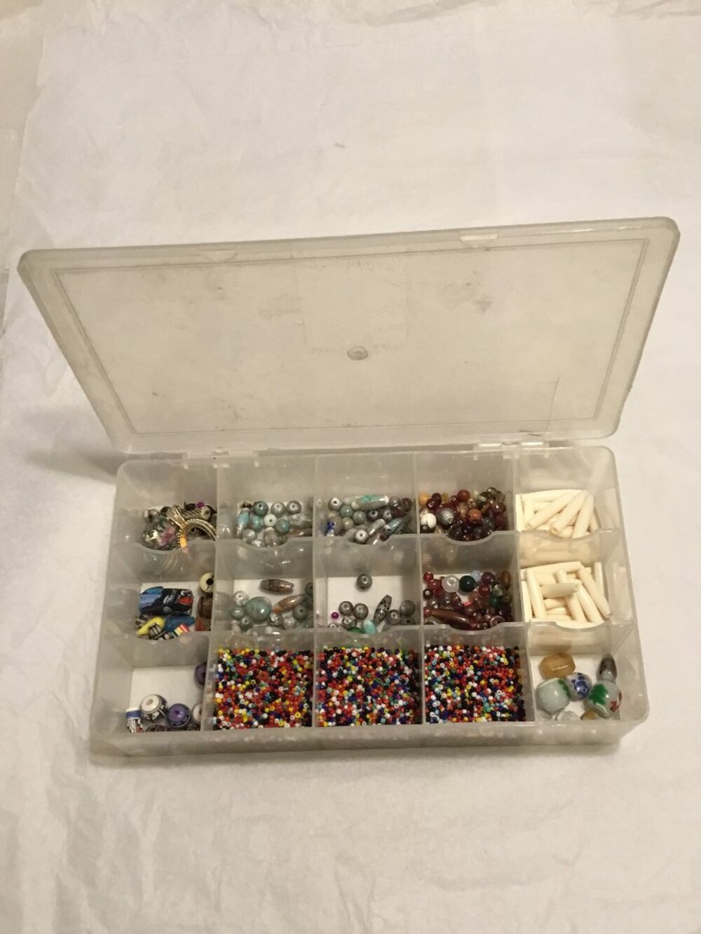 Hundreds & hundreds of colorful jewelry making beads in plastic container